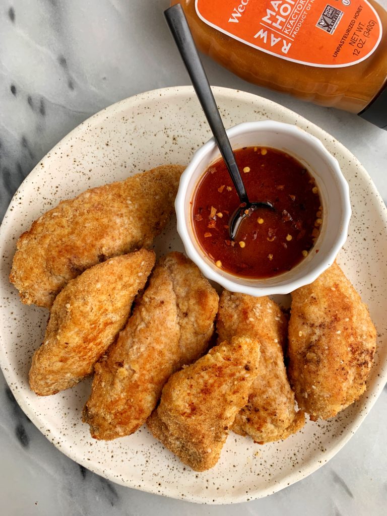 These Paleo Crispy Sesame Chicken Tenders with Spicy Honey Sauce are ready in just 20 minutes and they are gluten-free, nut-free and made with healthy ingredients like ground flaxseed, coconut flour and sesame seeds.