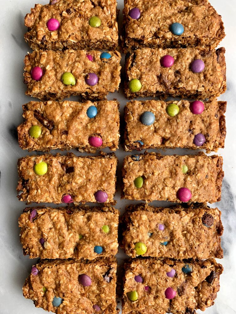 Healthier Gluten-free Monster Oatmeal Cookie Bars that taste like an oatmeal cookie dream! Filled with organic m&m candies and these oatmeal cookie bars are dairy-free, gluten-free and so delicious.