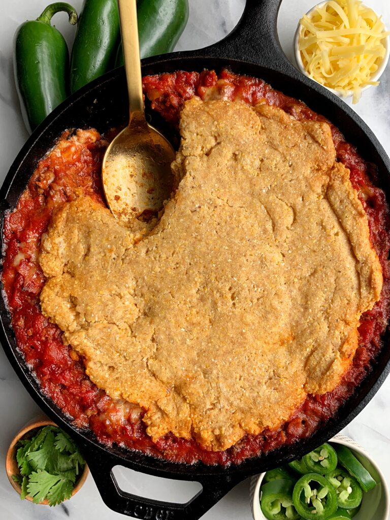 Healthy Bacon + Beef Chili Cornbread Casserole made with all gluten-free and dairy free-friendly ingredients. A delicious and easy meal to make for the whole family with a dreamy chili topped with homemade gluten-free cornbread.