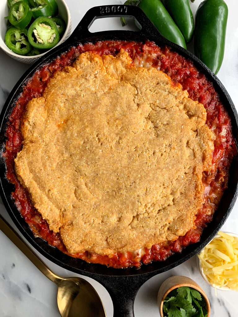 Healthy Bacon + Beef Chili Cornbread Casserole made with all gluten-free and dairy free-friendly ingredients. A delicious and easy meal to make for the whole family with a dreamy chili topped with homemade gluten-free cornbread.