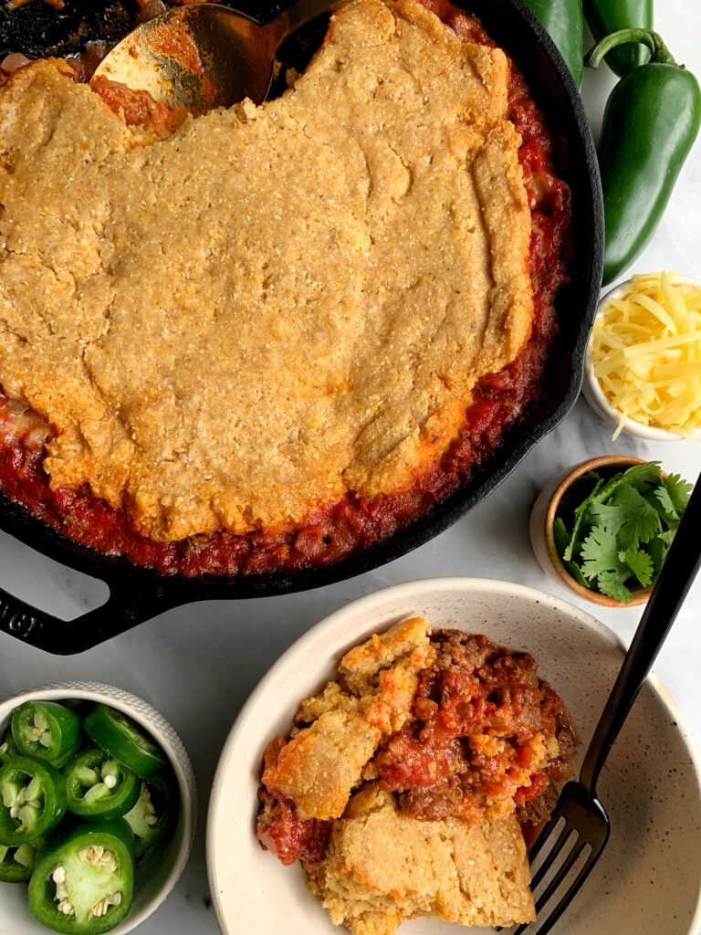 Healthy Bacon + Beef Chili Cornbread Casserole made with all gluten-free and dairy free-friendly ingredients. A delicious and easy meal to make for the whole family with a dreamy chili topped with homemade gluten-free cornbread.