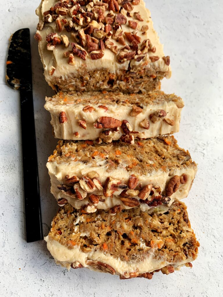 Vegan Carrot Cake Banana Bread with a dreamy and delicious cream cheese frosting! The ultimate gluten-free carrot cake banana bread made with all healthier ingredients and topped with cinnamon cream cheese frosting.