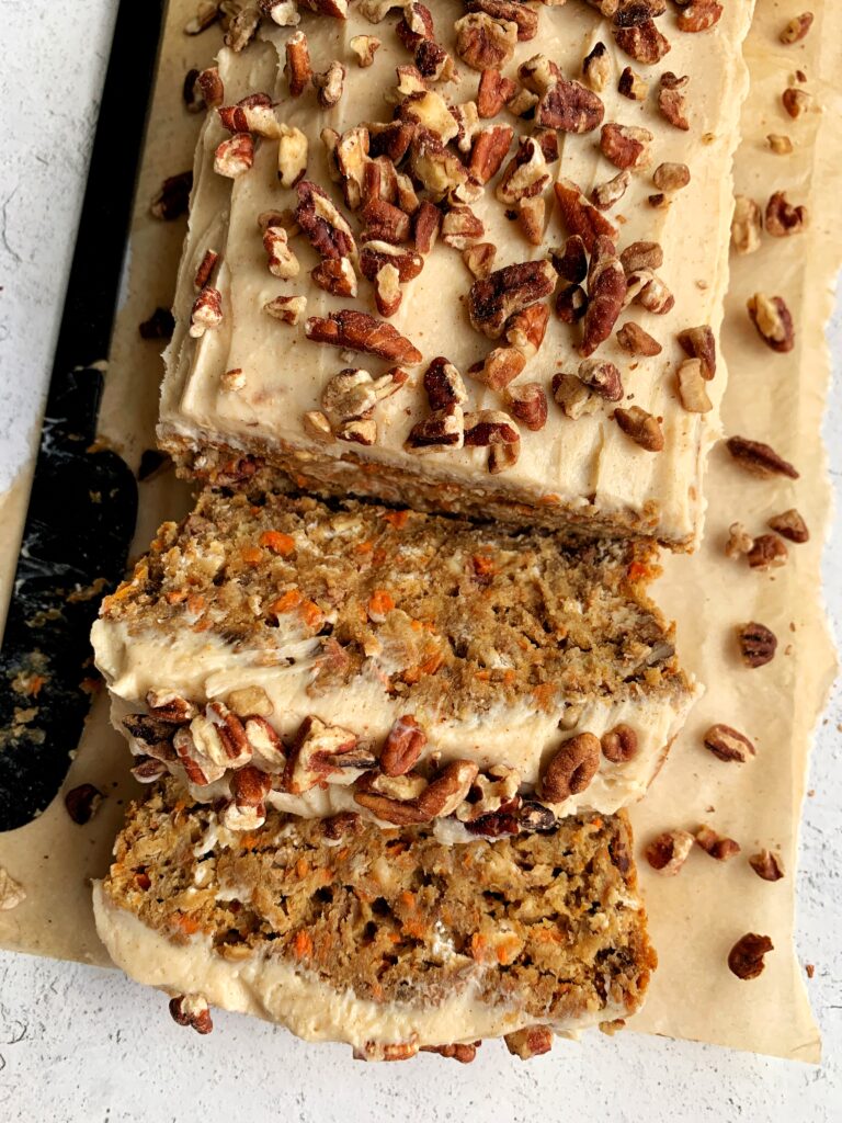 Vegan Carrot Cake Banana Bread with a dreamy and delicious cream cheese frosting! The ultimate gluten-free carrot cake banana bread made with all healthier ingredients and topped with cinnamon cream cheese frosting.