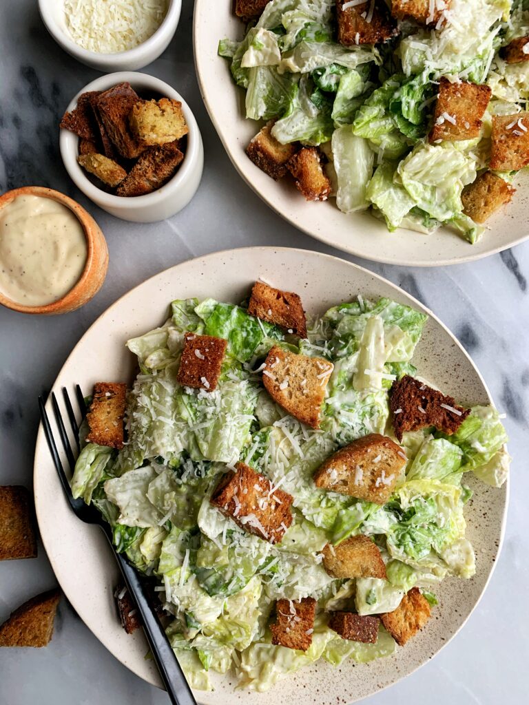 The Best Healthy Classic Caesar Salad with homemade caesar dressing, baked sourdough croutons on top of crunchy romaine with a sprinkle of fresh parmesan cheese.