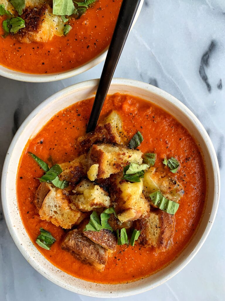 This healthier Vegan Creamy Tomato Soup with Grilled Cheese Croutons is the ultimate comfort food recipe! The dairy-free soup is made with 5 ingredients and topped with delicious grilled cheese made into "croutons".