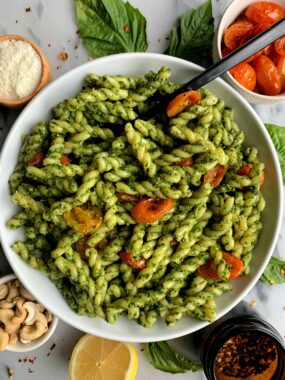 Vegan Cashew Kale Pesto Pasta made with all gluten-free and dairy-free ingredients. This easy pesto pairs perfectly with your favorite pasta and with some delicious roasted tomatoes mixed in for a dreamy vegan dish!