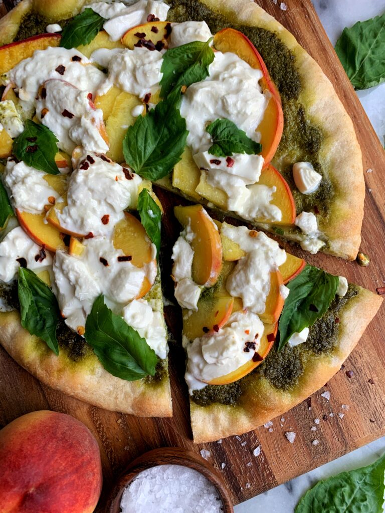 This Peach and Burrata Pizza with Balsamic Glaze is the ultimate peach flatbread recipe. Topped with pesto, peaches, burrata, fresh basil and a homemade balsamic glaze on top.