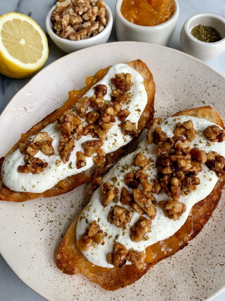 How to Make Epic Whipped Ricotta Toast topped with jam, candied walnuts and a little za'atar seasoning.