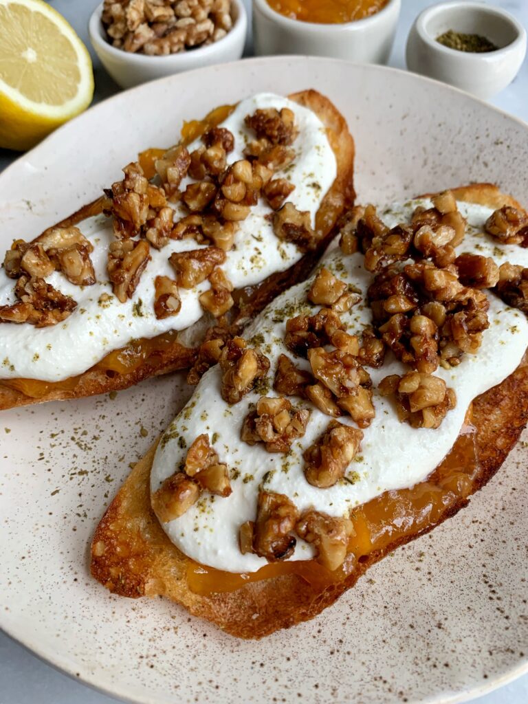 How to Make Epic Whipped Ricotta Toast topped with jam, candied walnuts and a little za'atar seasoning.