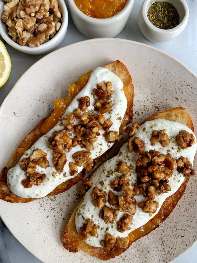 How to Make Epic Whipped Ricotta Toast topped with jam, candied walnuts and a little za'atar seasoning.