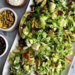 Crowd Pleaser Brussels Sprout Slaw! Made with raisins, pistachios, pears, pecorino and a simple dressing for an easy fall inspired salad.