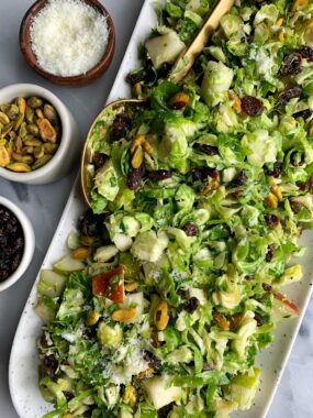 Crowd Pleaser Brussels Sprout Slaw! Made with raisins, pistachios, pears, pecorino and a simple dressing for an easy fall inspired salad.