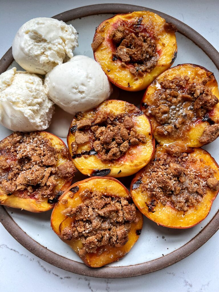 This Grilled Peach Crumble recipe is the ultimate dessert to make. Grilled cinnamon sugar peaches filled with a delicious crumb topping and ready in just 10 minutes.